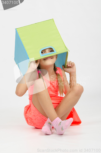 Image of Girl indulging in a box for toys put on the head