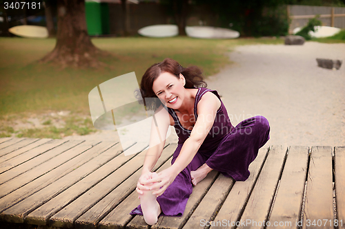 Image of Fit healthy young woman exercising on a jetty