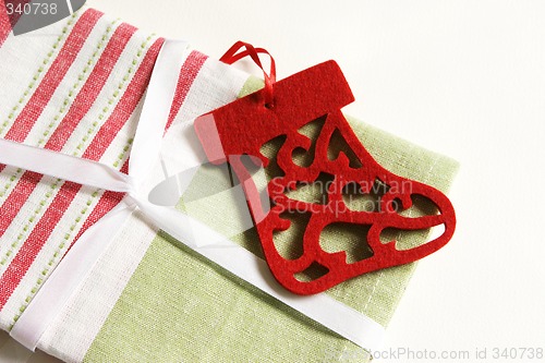 Image of Christmas gift wrapped in fabric and ribbon.