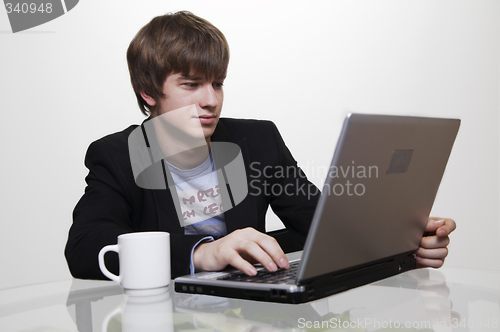 Image of confident young manager at work with laptop