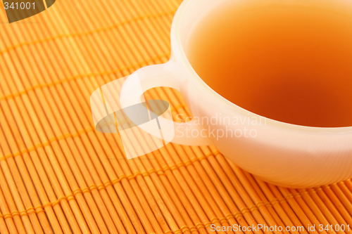 Image of Cup of tea on orange rattan mat