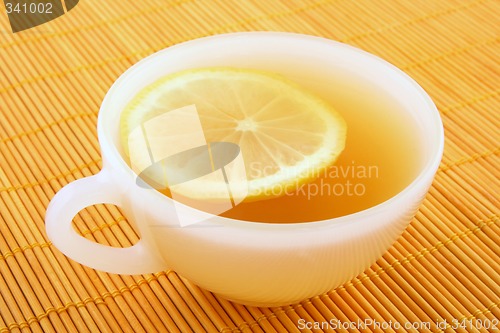 Image of Cup of tea with lemon in warm golden light