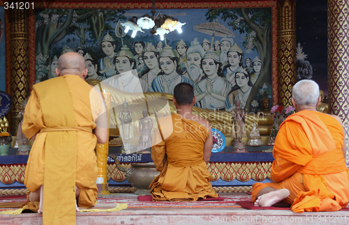 Image of three monks pray