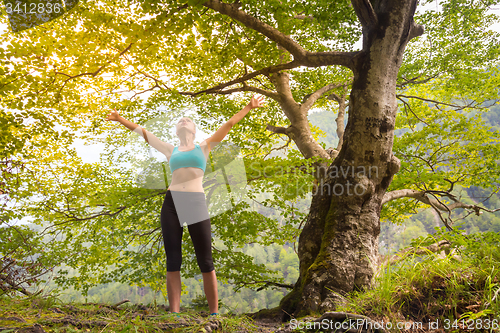 Image of Active sporty woman relaxing in beautiful nature.