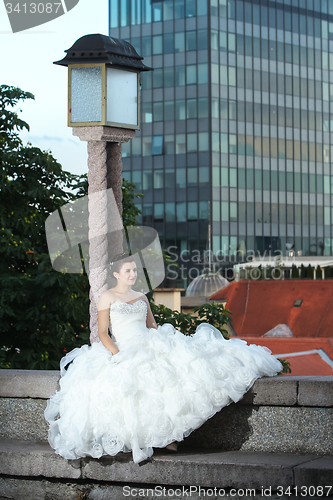 Image of Bride sitting next to street lamp