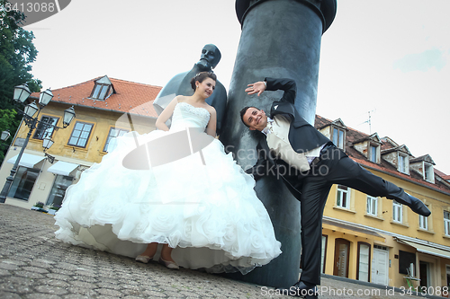 Image of Bride and groom goofing in front of August Senoa Monument