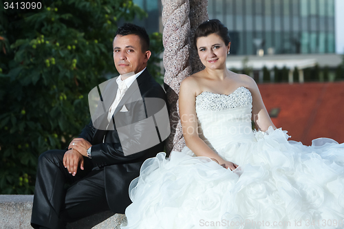 Image of Newlyweds posing next to pillar