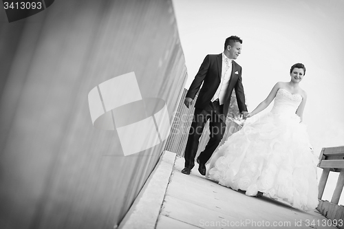 Image of Bride and groom walking in city bw