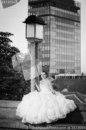 Image of Bride posing next to street lamp bw