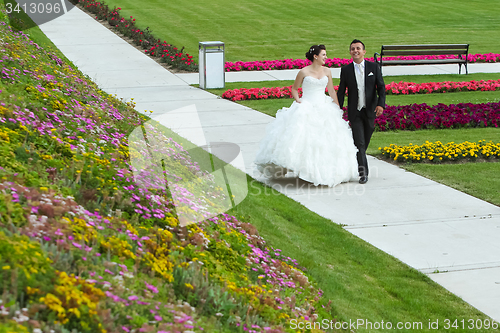 Image of Bride and groom walking on pathway