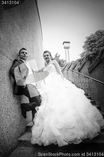 Image of Newlyweds posing on stone steps bw