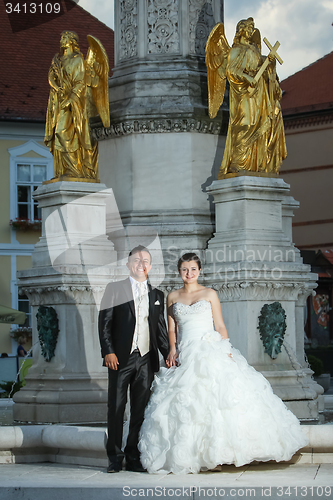 Image of Newlyweds standing in front of fountain