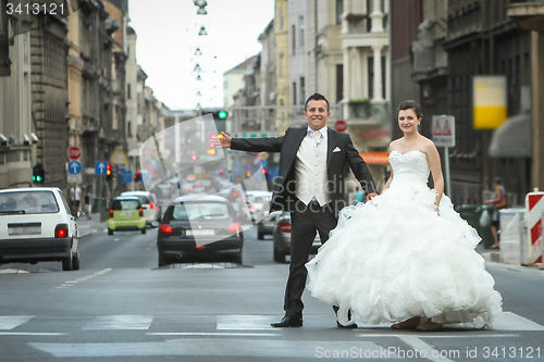 Image of Newlyweds standing on pedestrian crossing