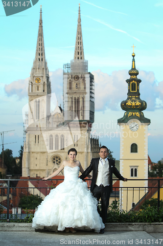 Image of Bride and groom posing in front of church