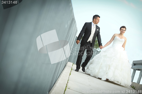 Image of Bride and groom walking in city