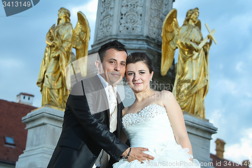 Image of Bride and groom posing in front of fountain