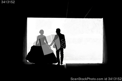 Image of Bride and groom walking in passage bw