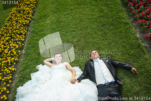 Image of Bride and groom on lawn with flowers