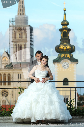 Image of Bride and groom posing in city