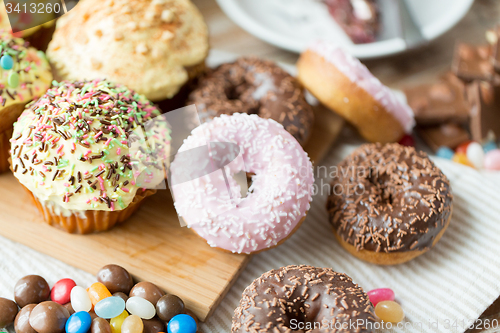 Image of close up of glazed donuts and sweets on table