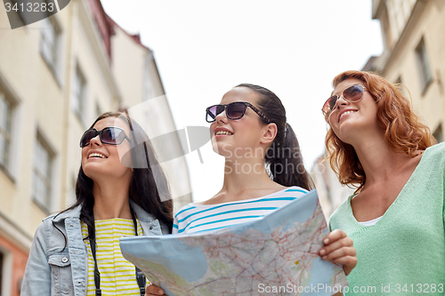 Image of smiling teenage girls with map and camera outdoors