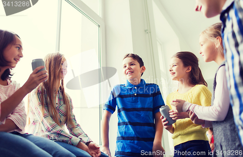 Image of group of school kids with soda cans in corridor