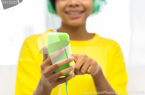 Image of happy african woman with smartphone and headphones