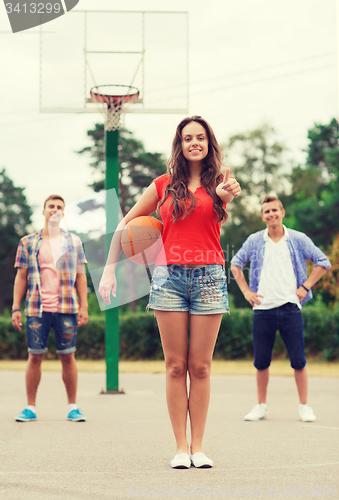 Image of group of smiling teenagers playing basketball