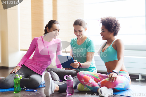 Image of group of happy women with tablet pc in gym