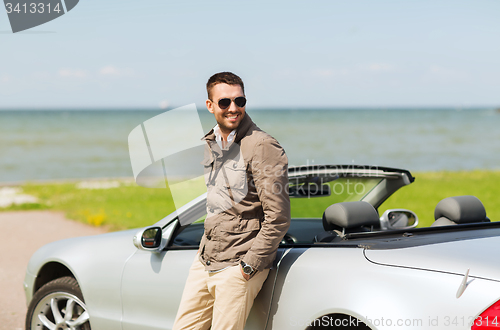 Image of happy man near cabriolet car outdoors