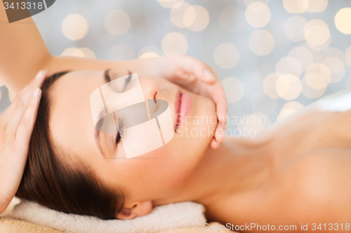 Image of beautiful woman in spa salon having facial massage