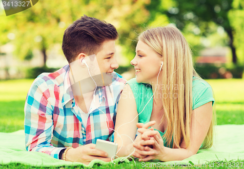 Image of smiling couple with smartphone and earphones