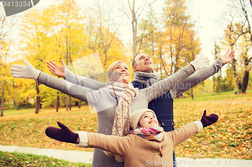 Image of happy family having fun in autumn park