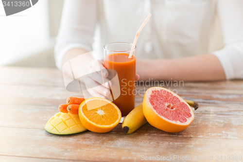 Image of close up of woman hands with juice and fruits