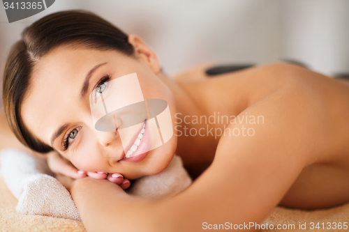 Image of beautiful woman in spa salon with hot stones