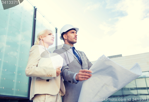 Image of businessmen with blueprint and helmets