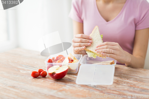 Image of close up of woman with food in plastic container