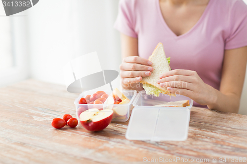 Image of close up of woman with food in plastic container