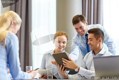 Image of smiling business people with tablet pc in office
