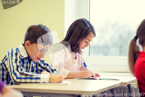 Image of group of school kids writing test in classroom