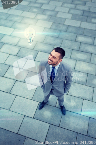 Image of young smiling businessman outdoors from top