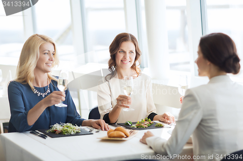 Image of happy women drinking champagne at restaurant