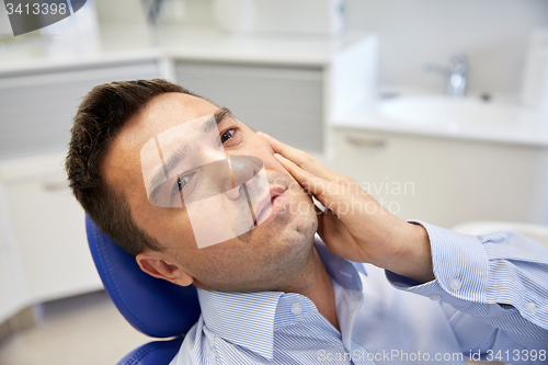 Image of man having toothache and sitting on dental chair