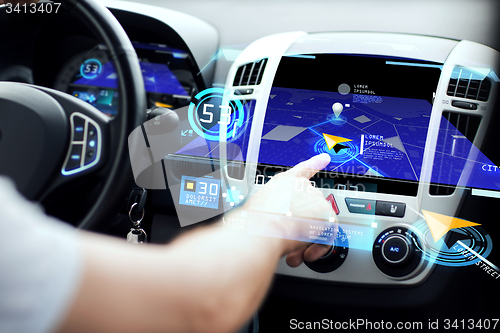 Image of male hand using navigation system on car dashboard