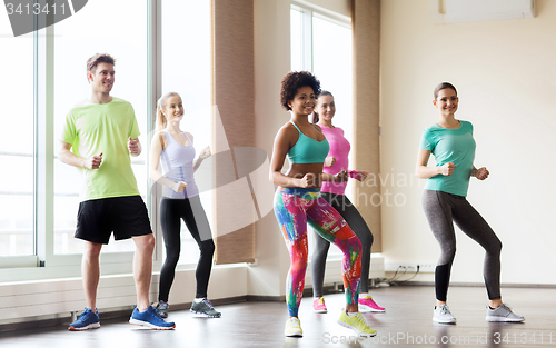 Image of group of smiling people dancing in gym or studio