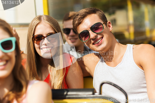 Image of group of smiling friends traveling by tour bus