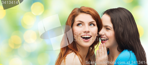 Image of teenage girls or women whispering gossip