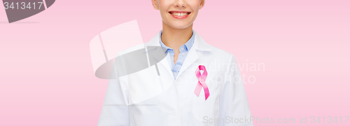 Image of smiling female doctor with cancer awareness ribbon