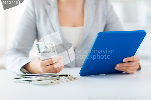 Image of close up of woman hands with tablet pc and money