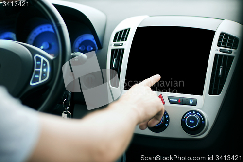 Image of male hand pointing finger to monitor on car panel